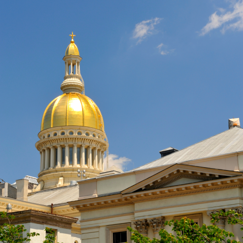 Golden dome of New Jersey capitol building against blue sky