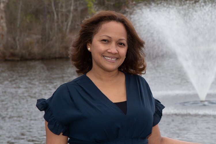 Celeste in a navy blue blouse in front of a water fountain