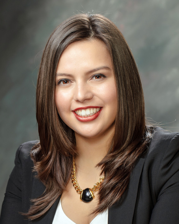 Sara Sooy in a black blazer in front of a gray background