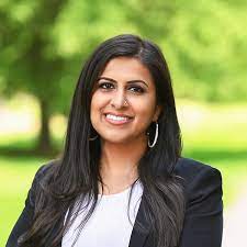 Sadaf Jaffer in a black blazer outside in front of a blurred background