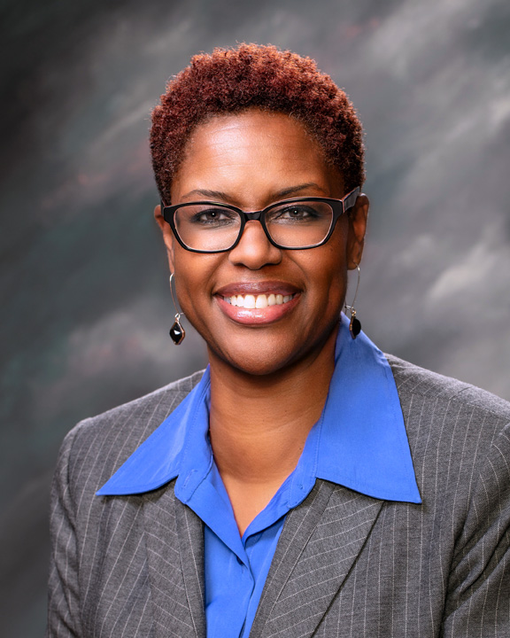 Shanel Robinson in a gray blazer in front of a gray background