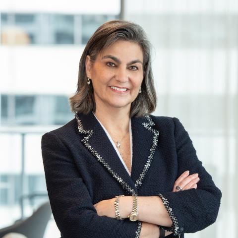 Eva pusateri in a black blazer in front of a blurred background