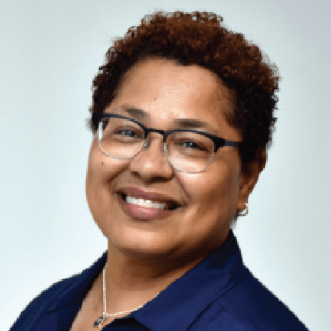 Head shot of Rebecca Williams wearing dark blue shirt against a gray background