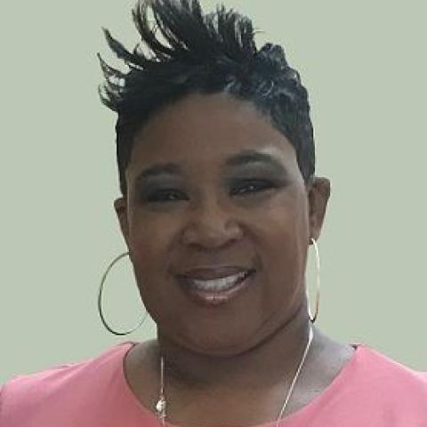 Head shot of Felicia Hopson wearing a pink shirt against a tan background