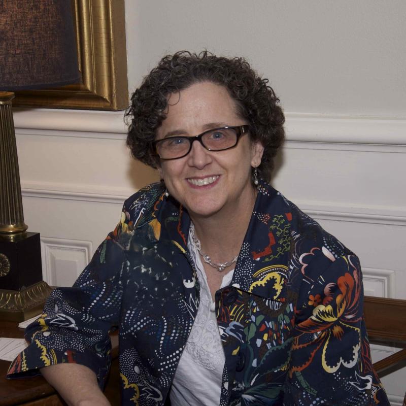 Kathy Kleeman seated in chair, wearing colorful patterned jacket and white blouse