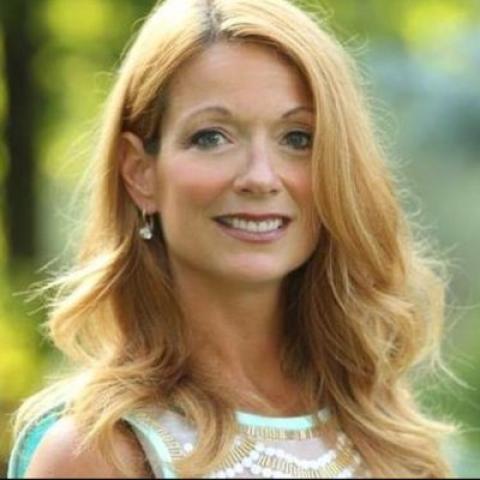 Head shot of Jeanette Hoffman against a green background