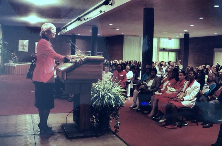 Shirley Chisholm stands at podium at CAWP event