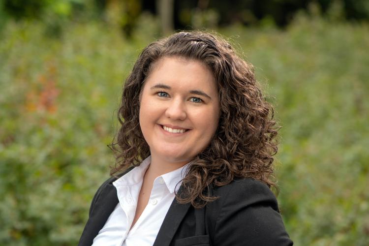 Annabelle Hutchinson in a black blazer with a blurry background with greenery