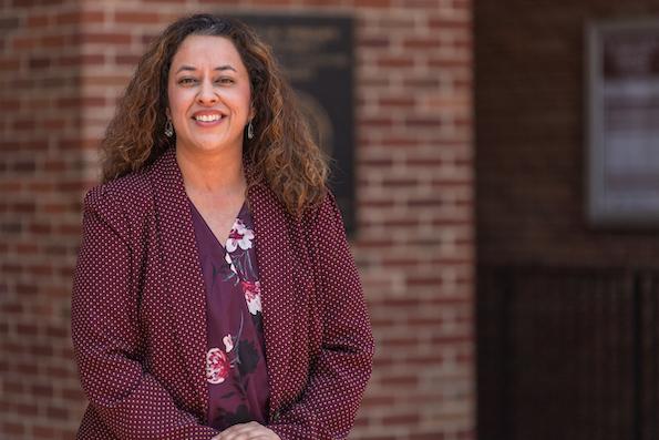 Christina Bejarano in a blazer in front of a blurred brick wall