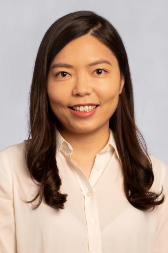 Jeong Hyun Kim in a cream blouse in front of a gray background