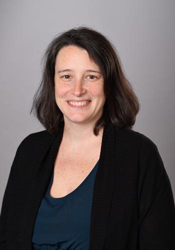 Jennifer Lucas in a black blazer in front of a gray background