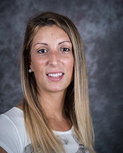 Martina Santia in a white blouse in front of a dark gray background