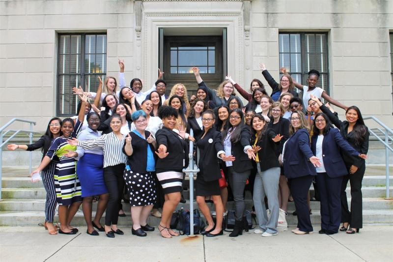 Large group of students standing on gray steps in front of Statehouse building