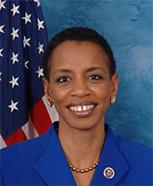 Donna Edwards posing in front of American flag wearing a blue suit jacket