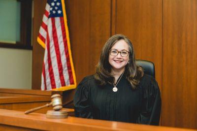 Tiffany Palmer dressed in black robe behind bench in court room.