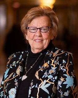 Loretta Weinberg smiles wearing black shirt and black suit jacket with bright floral print