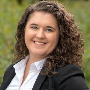 Annabelle Hutchinson in a white shirt and black blazer in front of a blurred green background