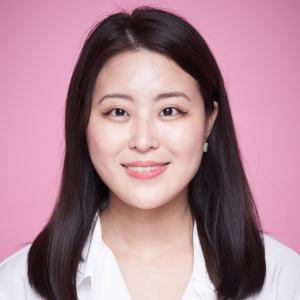 Cana Kim in white blouse in front of pink background