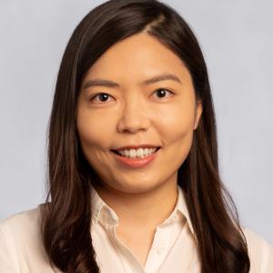 Jeong Hyun Kim in a cream blouse in front of a gray background