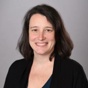 Jennifer Lucas in a black blazer in front of a gray background