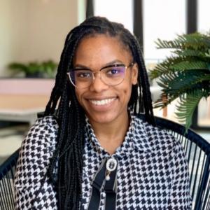 Adrienne Wright wearing patterned blouse smiling in chair