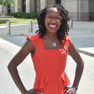 Nadia Brown in an orange top standing outdoors