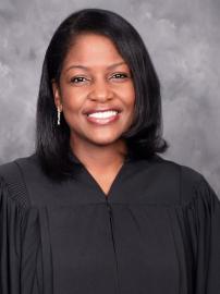 Justice Fabiana Pierre-Louis wearing a black robe against a gray background. 